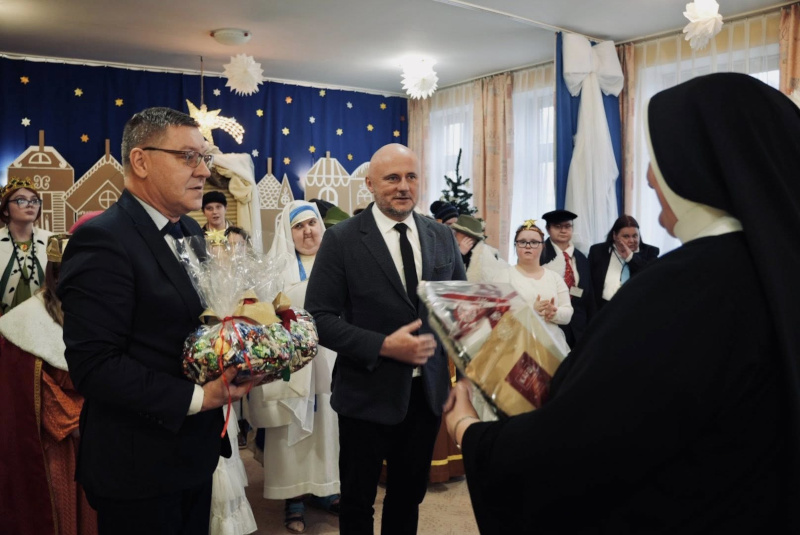 Wicestarosta Wojciech Jerzy Szczudło oraz Skarbnik Powiatu Mirosław Krakowski przekazują życzenia i upominek na ręce Dyrektor Domu Pomocy Społecznej w Augustowie s. Heleny Kamińskiej podczas spotkania opłatkowego